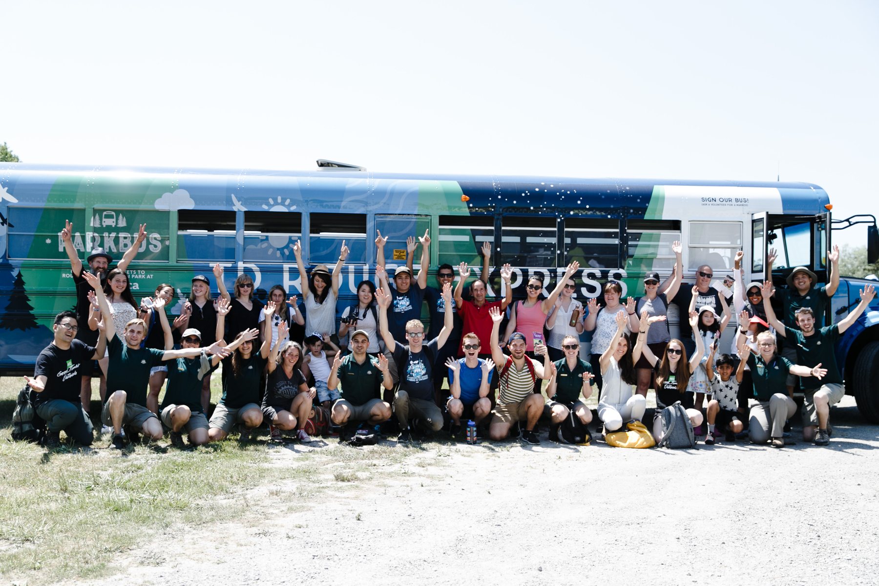 Riders cheering in front of the Toronto Zoo Express bus